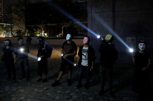 People wearing Anonymous masks use flashlights during an anti-government protest in Hong Kong, China, October 18, 2019. REUTERS/Umit Bektas