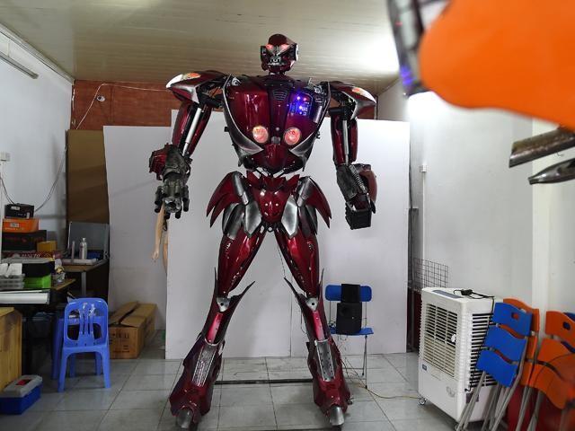 This photograph taken on September 30, 2019 shows a man looking at a new robot-model next to "Robot-One" (L), made from spare motorcycle parts, at a workshop in Hanoi. A team of IT programmers and students say they want to provoke debate about the scourge of discarded and unused autoparts in a city where nearly six million motorbikes hit the streets daily. Nhac NGUYEN/AFP