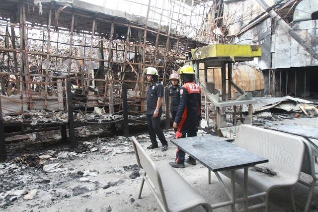 Bureau of Fire Protection-Pasay personnel led by Fire Inspector Paul Pili (left) inspect what remains of amusement park Star City in Pasay City on Sunday, October 6, 2019. Pili concluded that the cause of the fire that occurred on Oct. 2 is arson due to the gasoline substance found in the area. DANNY PATA