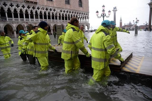 Workers install a mobile bridge in flooded St. Mark Square in Venice on the morning of November 17, 2019 prior to an "acqua alta" or high water of 160 centimetres (over five feet) expected at midday. Filippo Monteforte/AFP