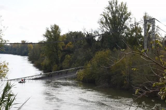 Rescuers sail near a suspension bridge which collapsed on November 18, 2019 in Mirepoix-sur-Tarn, near Toulouse, southwest France. A 15-year-old girl was killed when the collapse caused a car, a truck and possibly a third vehicle to plunge into the water, local authorities said. Four people were rescued but several others were feared missing after the collapse of the bridge linking the towns of Mirepoix-sur-Tarn and Bessieres, said fire service and local security chief Etienne Guyot. Eric Cabanis/AFP