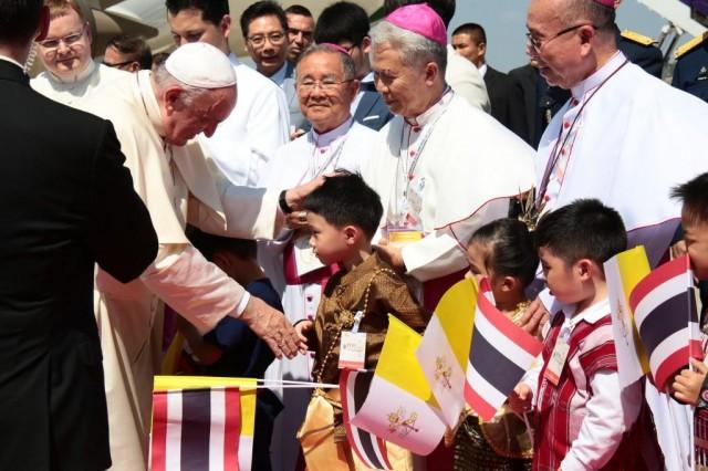 In this handout photo released and taken by the Thai Organizing Committee on November 20, 2019, Pope Francis greets a Thai child during arrival at the Military Air Terminal at Don Muang airport in Bangkok. Pope Francis arrived in Thailand on November 20, the first leg of an Asian tour that will sweep in Japan and carry a message of interreligious dialogue and nuclear disarmament. Handout / THAI ORGANIZING COMMITTEE / AFP