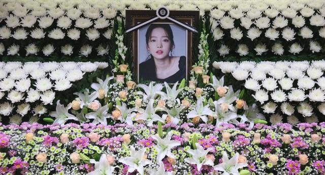 The portrait of Goo Hara is seen surrounded by flowers at a memorial altar at a hospital in Seoul on November 25, 2019. Fans mourned and questions were asked after the K-pop star and revenge porn victim was found dead in a possible suicide, which would make her the second female singer in a month to take her own life in the high-pressure industry. str/Dong-A Ilbo/AFP
