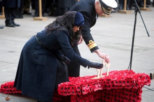 Meghan, Duchess of Sussex, places a small cross during a visit to the Field of Remembrance at Westminster Abbey in London, Britain, November 7, 2019. REUTERS/Hannah McKay