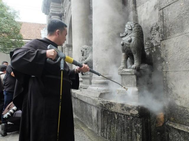 Fr. Villar taking part of the San Agustin's cleanup Thursday. Photo: Margaret Claire Layug/GMA News