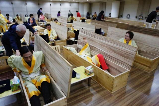 Participants get into coffins during a "living funeral" event as part of a "dying well" program, in Seoul, South Korea, October 31, 2019. Picture taken on October 31, 2019. REUTERS/Heo Ran