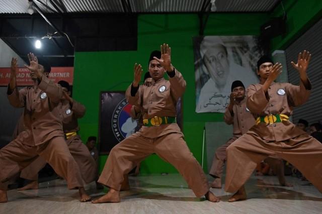 This picture taken on December 14, 2019 shows pencak silat practitioners, a martial art indigenous to Southeast Asia, taking part in a session in Jakarta. The term "pencak silat" describes hundreds of indigenous combat styles in Southeast Asia dating back to as early as the 6th century which blend self-defense and artistic elements. Bay Ismoyo/AFP