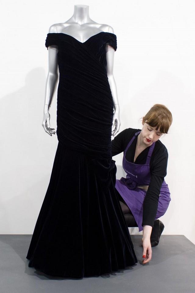 A staff member poses with the Victor Edelstein evening gown at the Kerry Taylor Auctions house in south London on March 15, 2013. Leon Neal, AFP