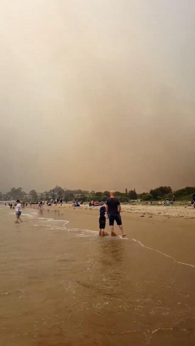  A crowd of people at the beach evacuate from the bushfires at Batemans Bay, Australia December 31, 2019 in this still image taken from social media video. INSTAGRAM @LAPPINGTHEISLAND via REUTERS