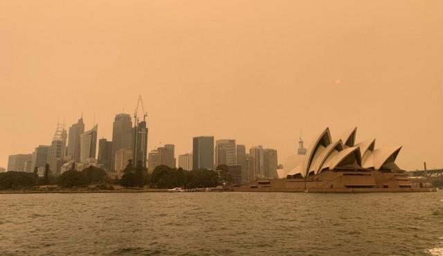 The haze from bushfires obscures the sun setting above the Sydney Opera House in Sydney, Australia, December 6, 2019. REUTERS/John Mair