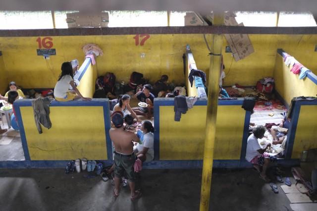 Families eating and resting at Bauan Cockpit Arena which now serves as an evacuation center. Photo by LJ Pasion, Save the Children