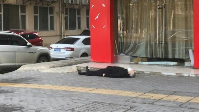 A grey-haired man wearing a face mask lies dead on the pavement at ground zero of China's virus epidemic, a plastic shopping bag in one hand. AFP could not determine how the man, who appeared to be aged in his 60s, had died. In the two hours that AFP observed the scene on Thursday, at least 15 ambulances passed by, attending other calls. HECTOR RATAMAL/LEO RAMIREZ/AFPTV