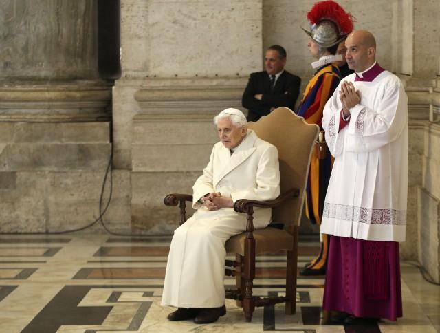 Emeritus Pope Benedict XVI sits near the Holy Door as Pope Francis leads a mass to mark opening of the Catholic Holy Year, or Jubilee, in St. Peter's Square, at the Vatican, December 8,2015. REUTERS/Max Rossi/File Photo