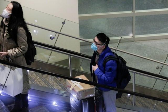 Travelers wearing masks arrive on a direct flight from China, after a spokesman from the U.S. Centers for Disease Control and Prevention (CDC) said a traveller from China had been the first person in the United States to be diagnosed with the Wuhan coronavirus, at Seattle-Tacoma International Airport in SeaTac, Washington, U.S. January 23, 2020. REUTERS/David Ryder