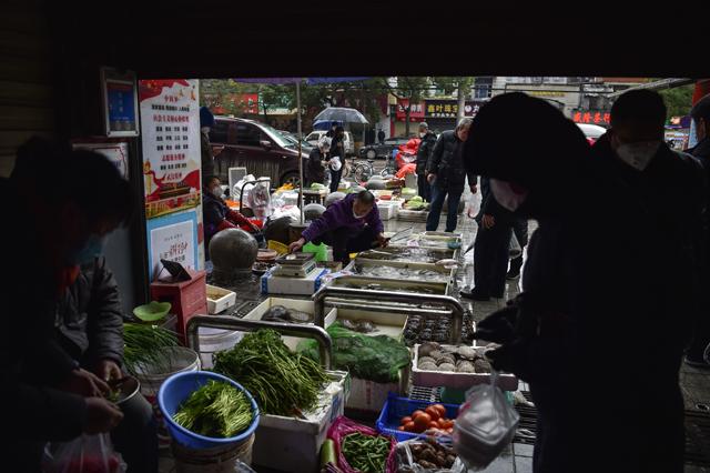 Sellers and costumers wearing face masks to help stop the spread of a deadly virus which began in the city are seen at a market in Wuhan in China's central Hubei province. --Agence France-Pesse 