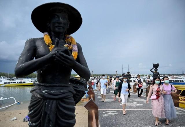 Chinese tourists wearing facemasks arrive at the fast boat pier in Serangan island in Denpasar on Indonesia's resort island of Bali on January 26, 2020. Sonny Tumbelaka/AFP