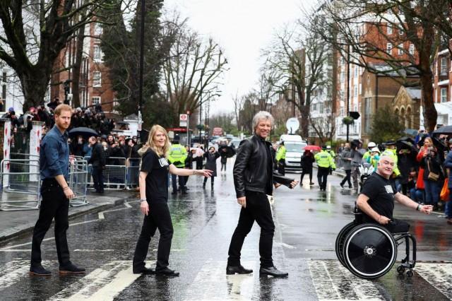 Britain's Prince Harry, Jon Bon Jovi and two choir members walk on the famous zebra crossing that The Beatles walked across, during a visit at Abbey Road Studios in London, Britain February 28, 2020. REUTERS/Henry Nicholls