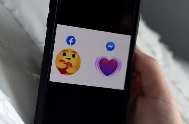 In this photo illustration, the two new â€˜careâ€™ emojis which show support for the fight against Coronavirus, in Facebook and Messenger are displayed on the screen of an iPhone on April 17, 2020, in Arlington, Virginia. The care Facebook emoji (L) will start appearing in Facebookâ€™s main app next week. Messenger's emoji will appear from April 17, 2020. Olivier DOULIERY / AFP