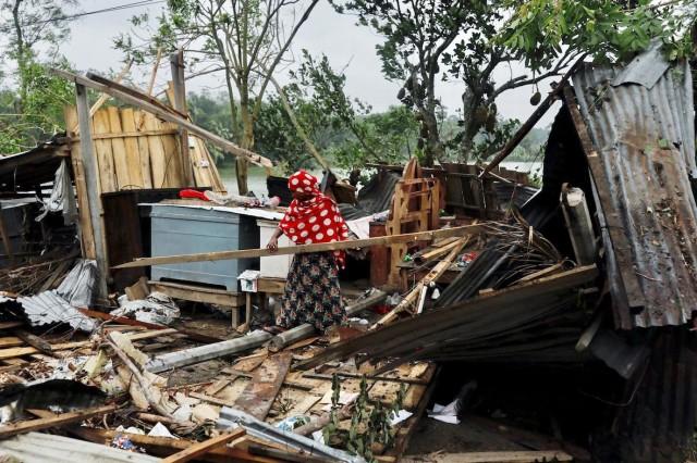 A woman clears her house that was demolished by the cyclone Amphan in Satkhira, Bangladesh May 21, 2020. REUTERS/Km Asad