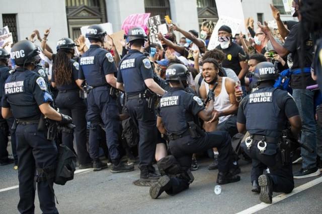A man screams with emotion as he sees a policeman take a knee while hundreds protest the death of George Floyd next to the White House on May 31, 2020 in Washington, DC. Thousands of National Guard troops patrolled major US cities after five consecutive nights of protests over racism and police brutality that boiled over into arson and looting, sending shock waves through the country. ROBERTO SCHMIDT / AFP 