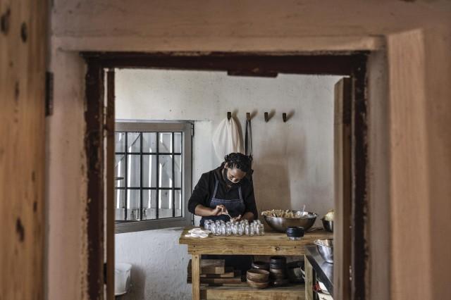 Alicia, a cook with South African Chef Kobus van der Merwe of the Wolfgat restaurant on the beach in Paternoster, is seen filling jars that will be delivered to customers on June 18, 2020. MARCO LONGARI / AFP