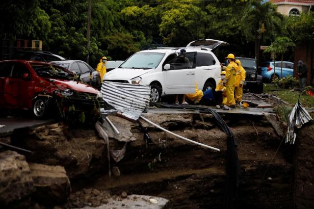 Government workers try to move a car affected by floods caused by Tropical Storm Amanda, at San Francisco neighborhood, in San Salvador, El Salvador May 31, 2020. REUTERS/Jose Cabezas