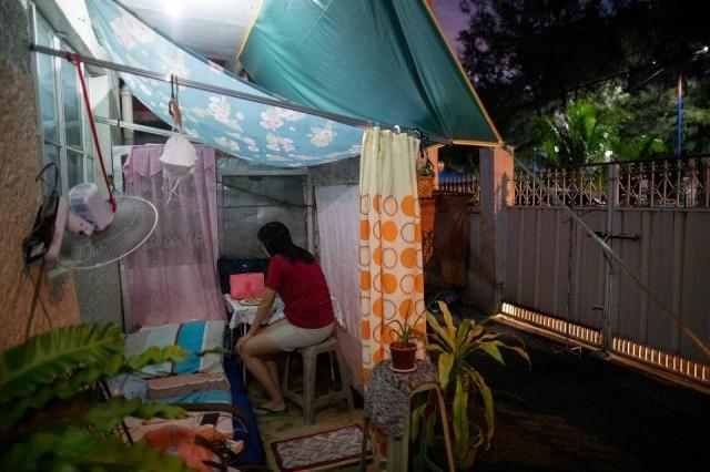 Mica Bastillo, 38, a pediatrician assigned to treat COVID-19 patients, eats dinner at a makeshift tent in their yard to protect her family from potential exposure to the coronavirus disease (COVID-19), in Marikina City, May 29, 2020. REUTERS/Eloisa Lopez