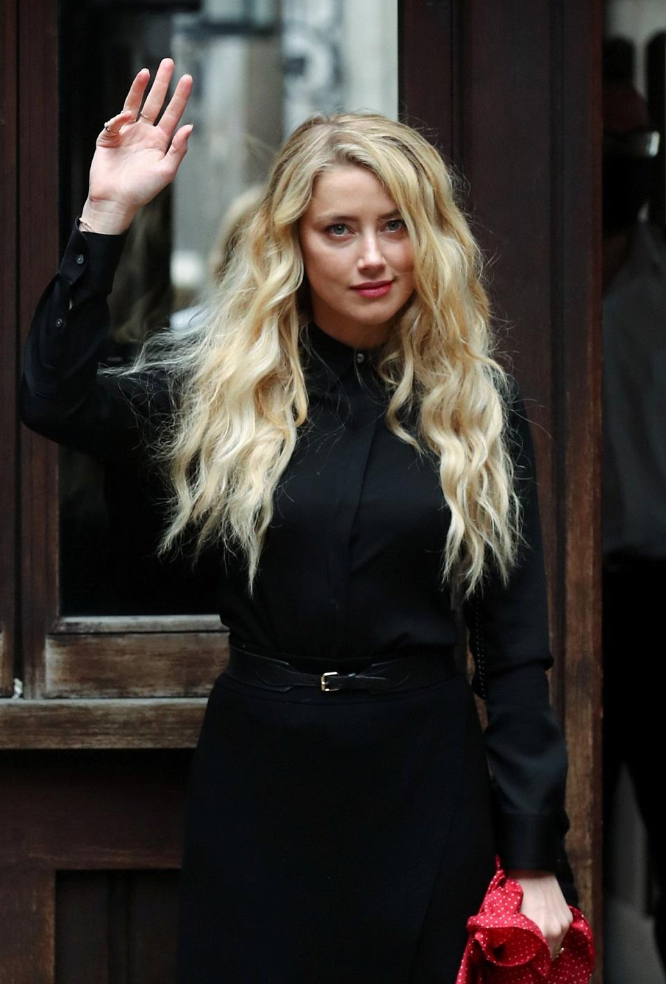 Actor Amber Heard waves as she arrives at the High Court in London, Britain July 28, 2020. REUTERS/Simon Dawson