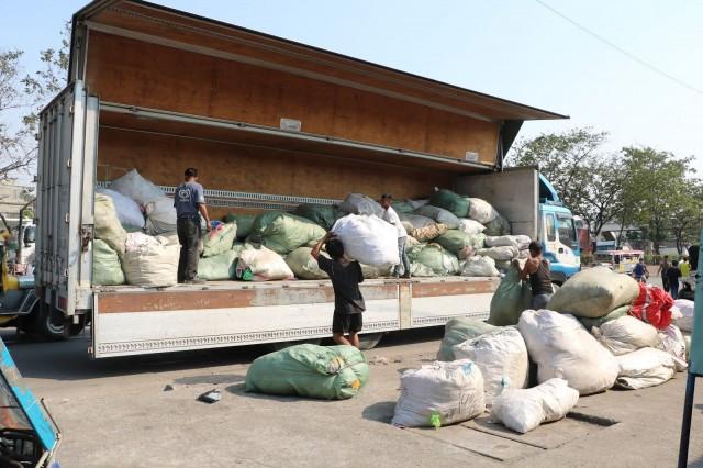 Workers affiliated with the Plastic Credit Exchange (PCEx) load collected plastic waste onto a 40-footer PCEx truck at Baseco in Tondo, Manila.