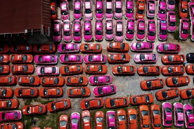 This aerial photo taken on July 20, 2021 shows scores of taxis left in a parking lot, after drivers were unable to pay rent on them due to the economic hardship of COVID-19 and more than a year of no incoming foreign tourism, in Bangkok. Lillian SUWANRUMPHA/AFP