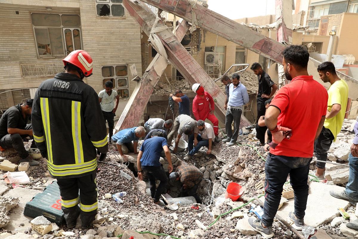 Iranians rescuers scour the rubble at the site where a ten-storey building collapsed, as rescue operations continue in the southwestern city of Abadan on May 24, 2022. Tasnim News/ AFP