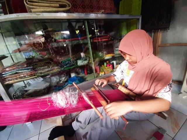 A young Yakan demonstrates the weaving process of Yakan tapestry.
