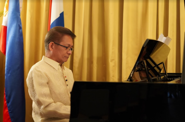 Philippine Ambassador J Eduardo Malaya plays the national anthem