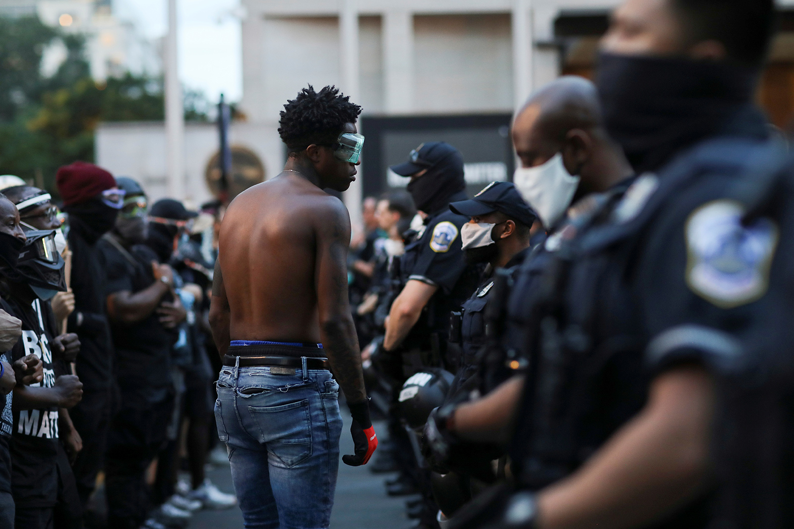 A demonstrator faces police officers near Black Lives Matter Plaza as racial inequality protests continue, in Washington, U.S.