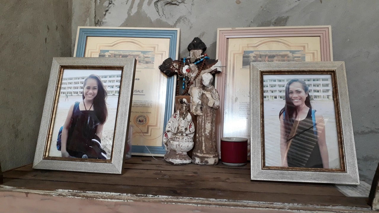 The portraits of 17-year-old twins Cherry Ann (left) and Cherry Rose (right) Cadusale now sit at their family altar at their home in Basay. Behind their pictures are posthumous awards given by the Basay government.