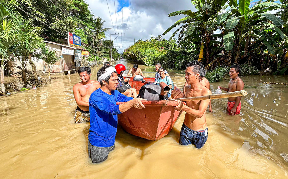 Residents wade through floodwaters in Jade Valley, one of the danger zones in Davao City