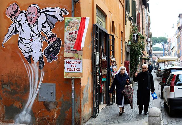 A large caricature of Pope Francis depicting him as a superhero is seen on a wall near the Vatican on January 29, 2014. Reuters/ Alessandro Bianchi/ File photo