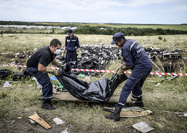 Ukrainian State Emergency Service personnel collect bodies of MH17 victims