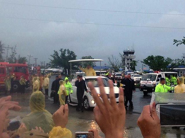 Under darkening skies as a storm approached, Pope Francis waves to the crowds in Tacloban City upon his arrival. Photo: Amanda Tan Fernandez