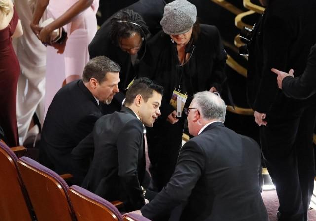 Best actor winner Rami Malek was helped by security staff after falling at the Oscars on Sunday (February 24). Photographs show security officials helping him up and into a seat following the incident in he which he fell down stairs on stage. REUTERS/Mike Blake