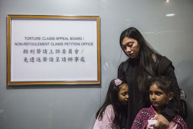 Filipino refugee Vanessa Rodel (c) waits with her daughter Keana (l) and Sethumdi (r), the daughter of Sri Lankan refugee Nadeeka Nonis (not in picture) outside an office of the Torture Claims Appeal Board building in Hong Kong on July 17, 2017. AFP