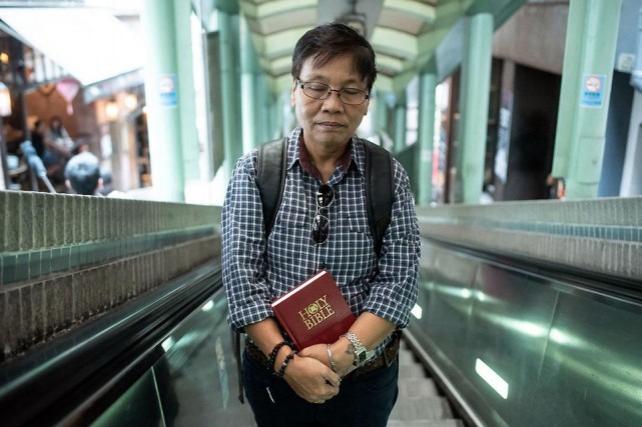 Filipino Christian pastor Marrz Balaoro holds a copy of the Bible while on an escalator at the Central district in Hong Kong on May 5, 2019. As a transgender pastor of a small Hong Kong church that welcomes all sexualities, Balaoro wants to conduct religious marriage ceremonies for same-sex couples but fears arrest — a battle he is now taking to the courts. AFP/Philip Fong