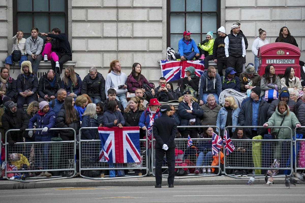 People wait along the route that the coffin of Britain's Queen Elizabeth II will be pulled on a gun carriage during her funeral service in Westminster Abbey in central London on September 19, 2022. The country's longest-serving monarch, who died aged 96 after 70 years on the throne, will be honored with a state funeral on Monday morning at Westminster Abbey. Emilio Morenatti/ Pool/ AFP