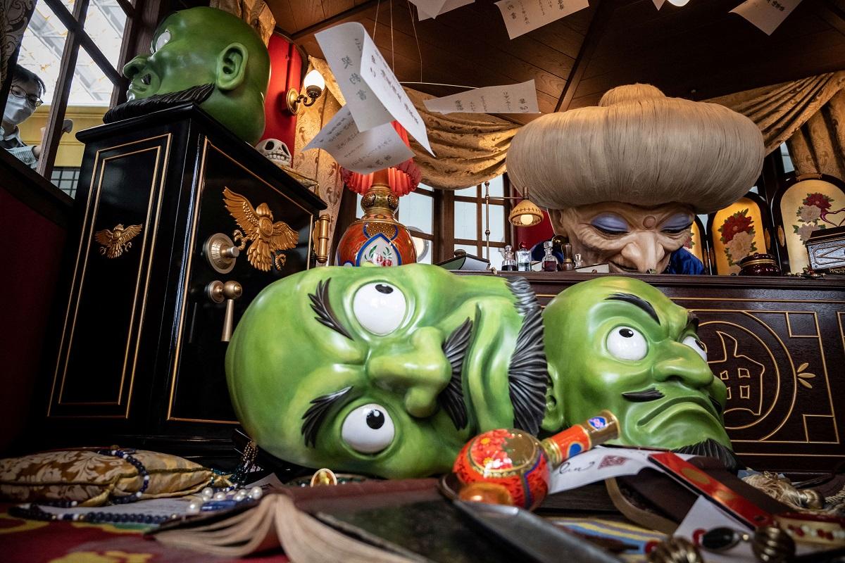 A member of staff (left) cleans the window of an exhibit at Ghibli's Grand Warehouse during a media tour of the new Ghibli Park in Nagakute, Aichi prefecture on October 12, 2022. Yuichi Yamazaki/ AFP