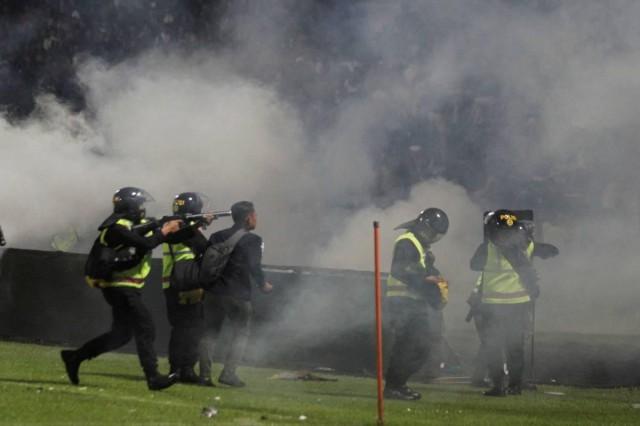 A riot police officer fires tear gas during riot after the league BRI Liga 1 football match between Arema vs Persebaya at Kanjuruhan Stadium, Malang, East Java province, Indonesia, October 2, 2022, in this photo taken by Antara Foto. Antara Foto/Ari Bowo Sucipto/via REUTERS ATTENTION EDITORS - THIS IMAGE HAS BEEN SUPPLIED BY A THIRD PARTY. MANDATORY CREDIT. INDONESIA OUT. NO COMMERCIAL OR EDITORIAL SALES IN INDONESIA.