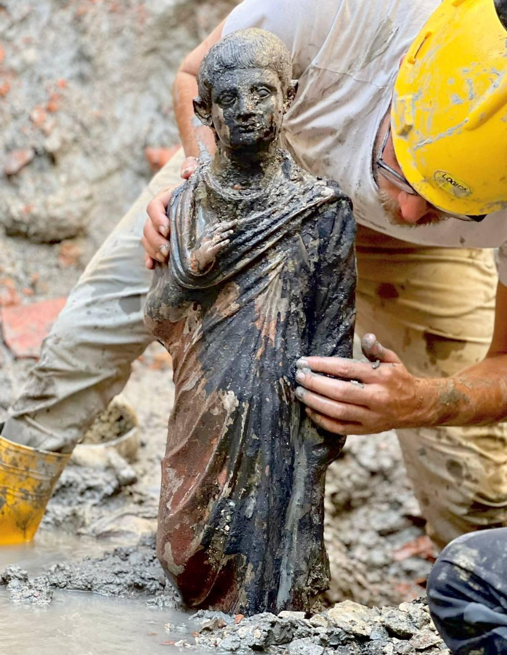 A worker holds a 2,300-year-old bronze statue which has been discovered in San Casciano dei Bagni, Italy, in this handout photo obtained by Reuters on November 8, 2022. Ministero della Cultura/ Handout via REUTERS