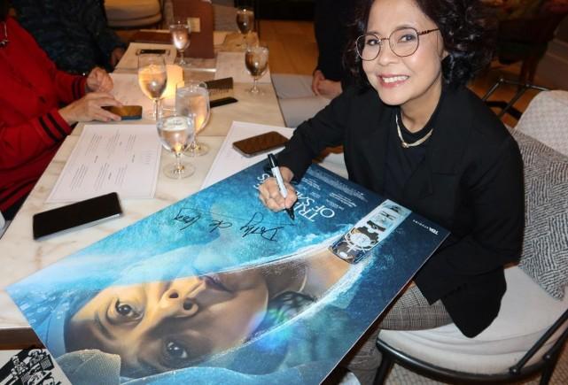 Dolly de Leon signs the poster of "Triangle of Sadness" for the Philippine theatrical release. Photo courtesy of Janet Susan R. Nepales