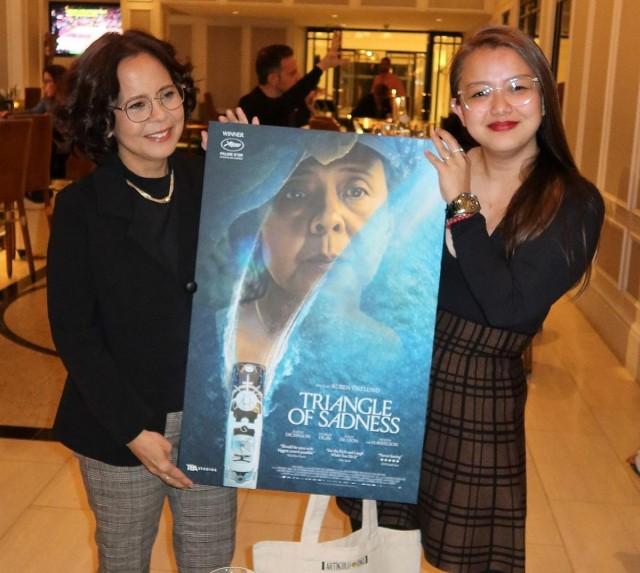 Dolly de Leon with TBA Studios President and COO Daphne Chiu holding the poster for the Philippine theatrical release of "Triangle of Sadness." Photo courtesy of Janet Susan R. Nepales