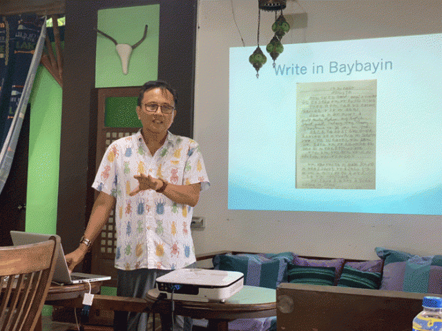 Howie se apresenta a um grupo de professores.  Ele mostra uma página de seu caderno escrita inteiramente em Baybayin.  Foto: Howie Severino