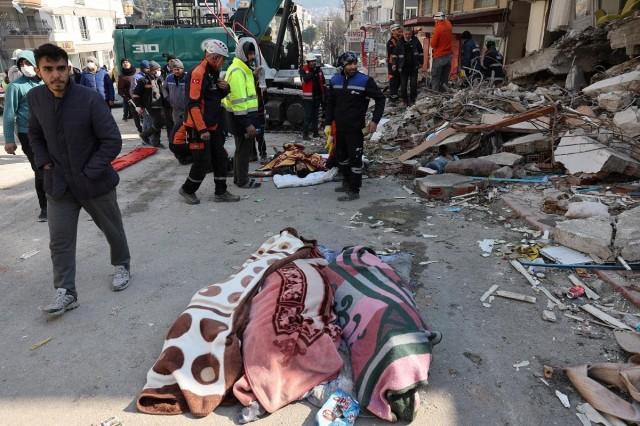 Abdulalim Muaini receives medical attention as the bodies of his wife Esra and daughters Mahsen and Besira lie on the ground nearby. REUTERS/ Umit Bektas